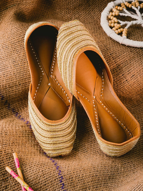 A pair of gold-toned embellished ethnic mojaris